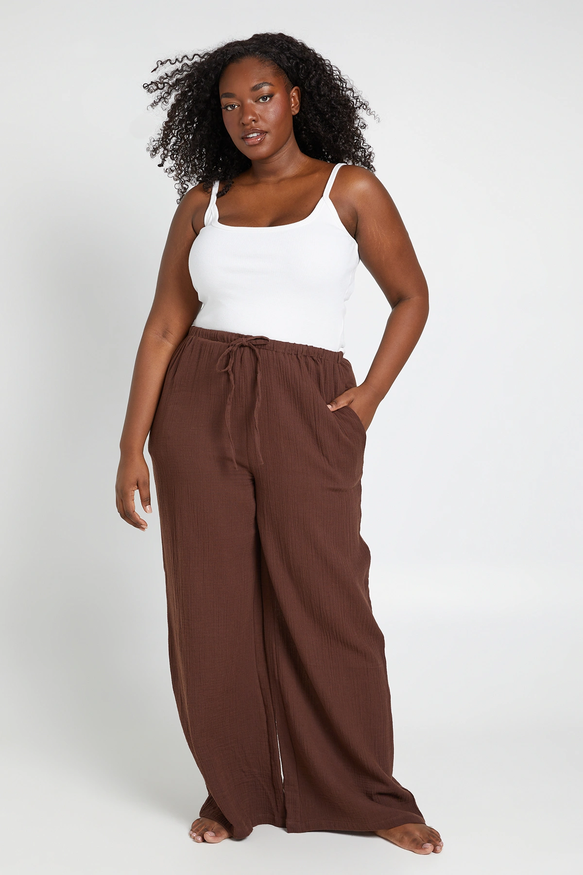Model wearing the chocolate Boohoo plus-size tie-front wide-leg beach trousers