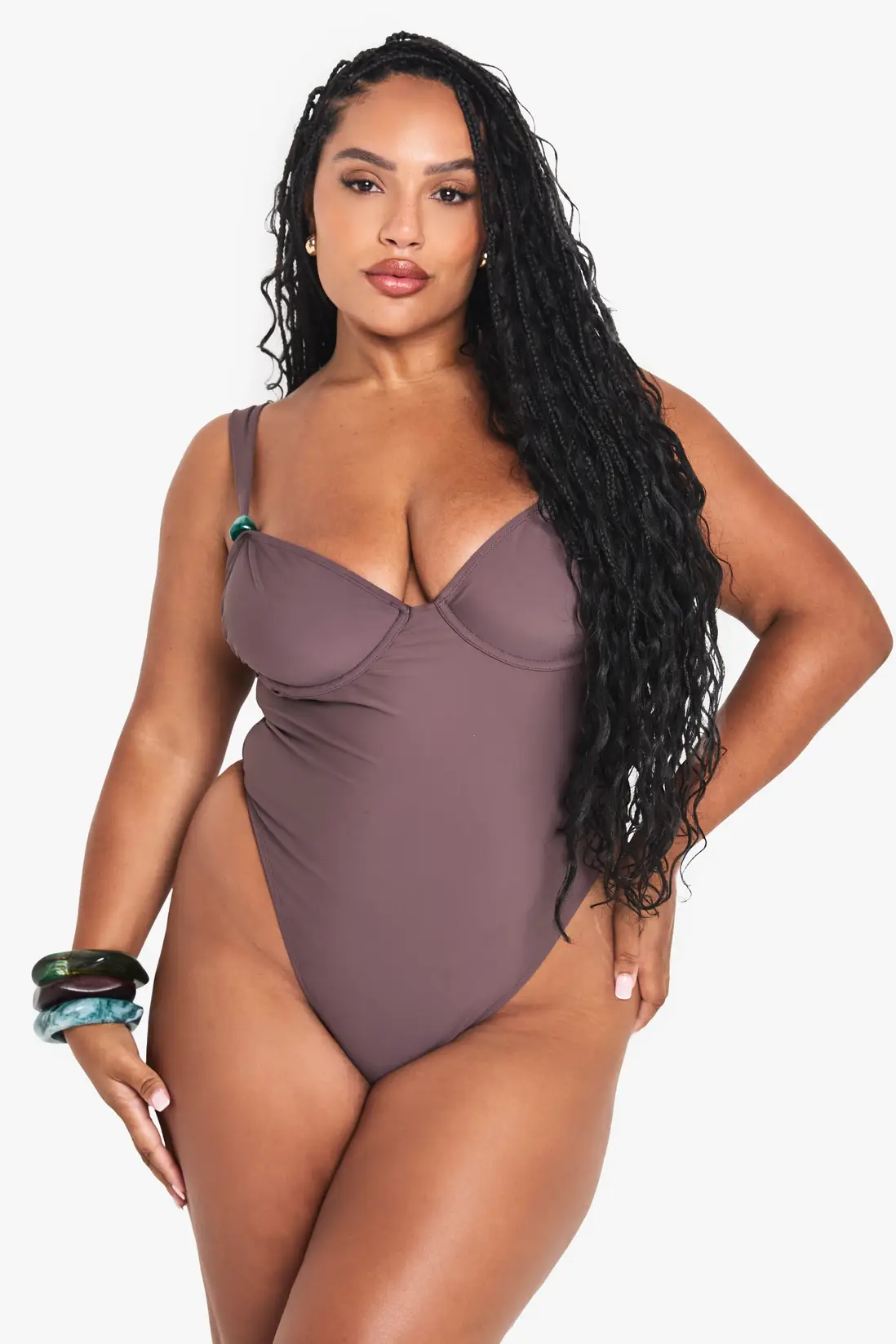 Model wearing the mauve-brown Boohoo underwire one-piece swimsuit with resin-trim straps