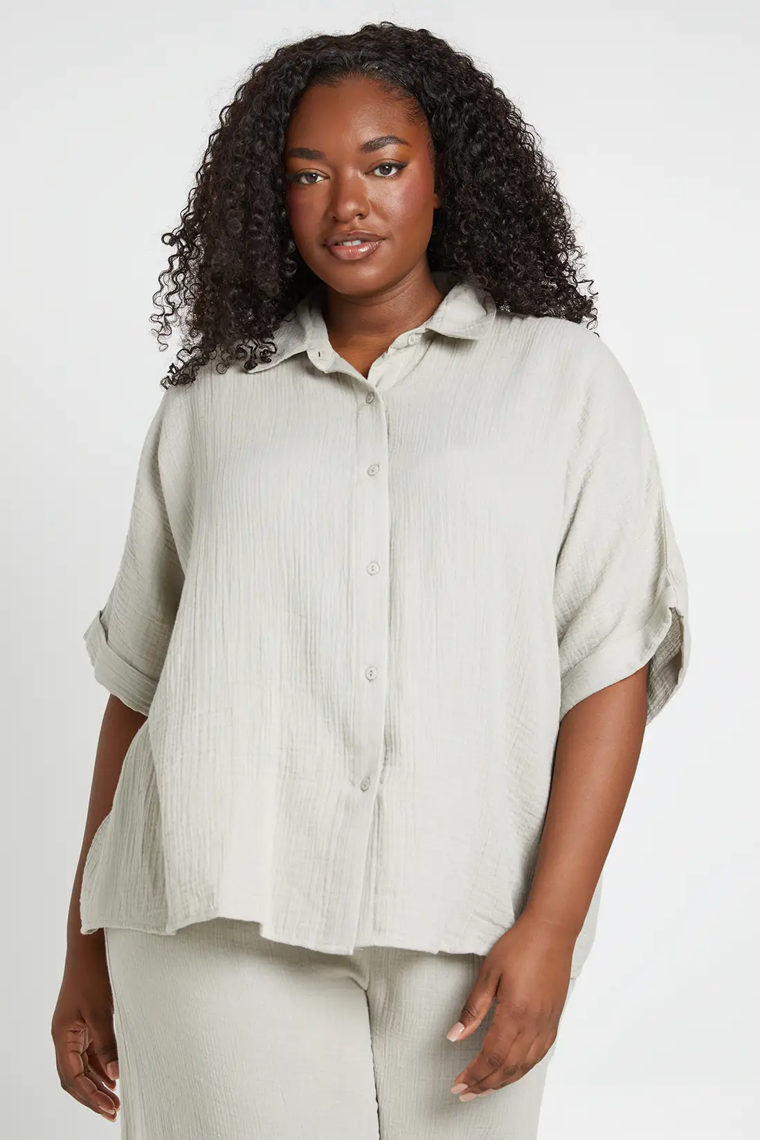Model wearing the stone Boohoo plus-size short-sleeve boxy beach shirt