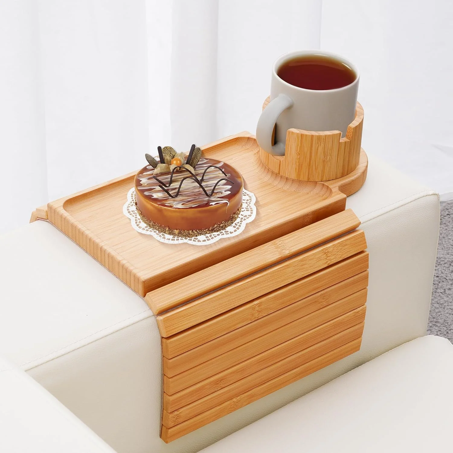 Bamboo couch-arm tray holding a mug and a small dessert.