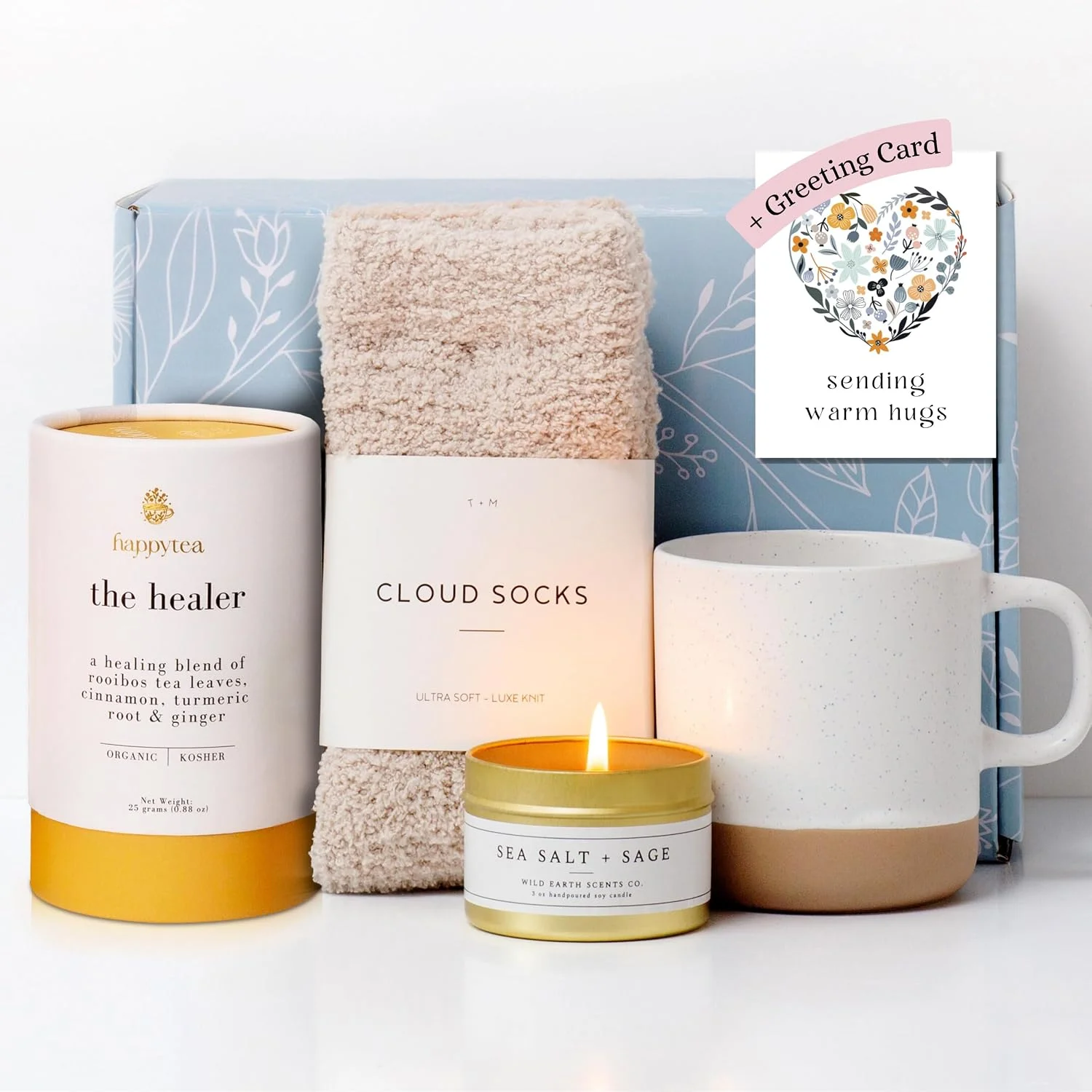 Unboxme care package with socks, tea, a mug, candle and greeting card.