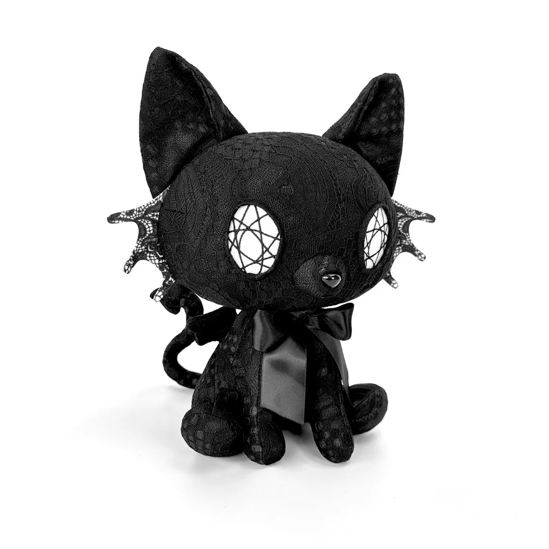 77 Best Christmas Gift Ideas That Feel Personal, Useful and Fun 72 Black lace vampire cat plush with white patterned eyes and a black bow.