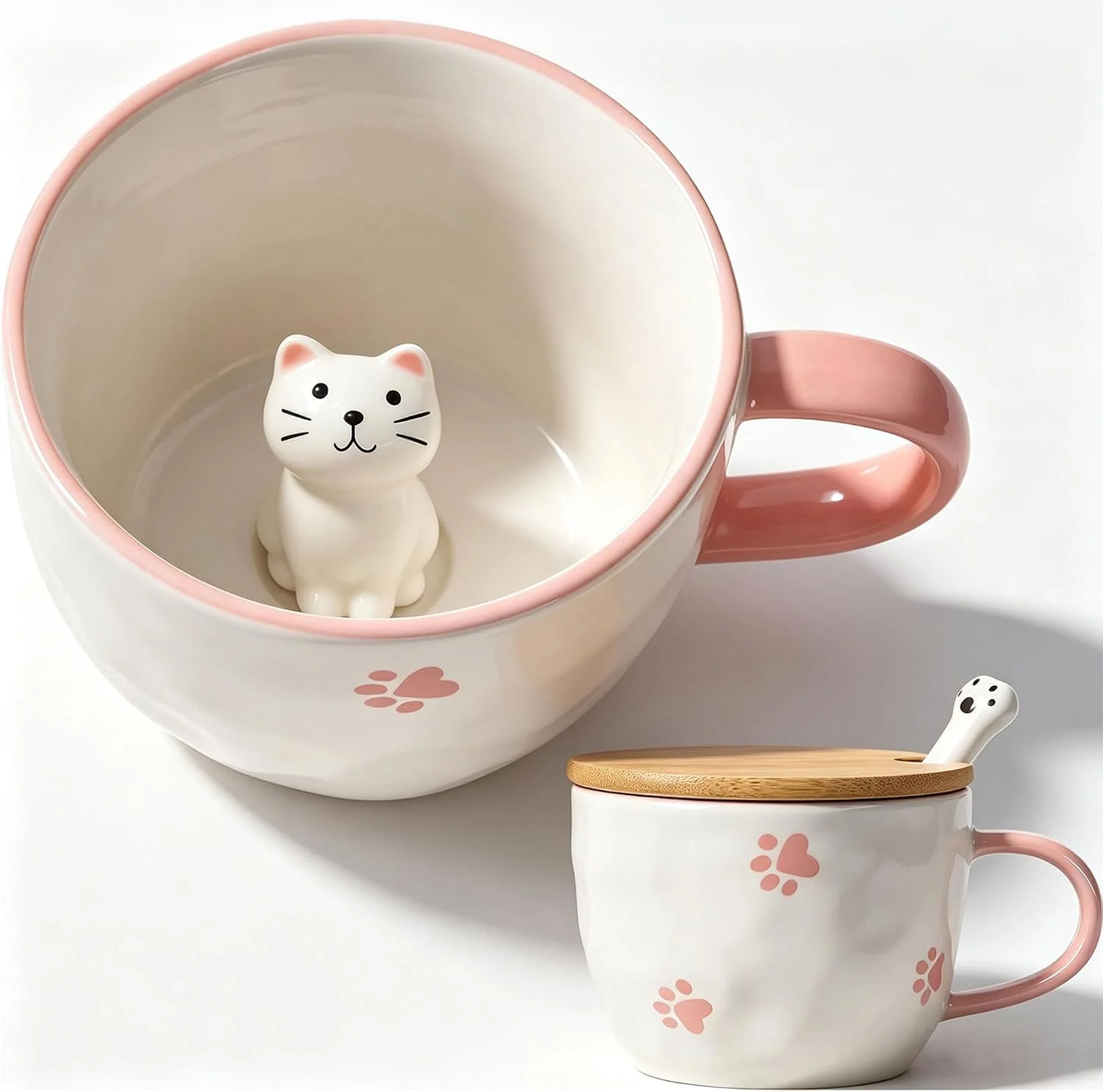 White mug with a pink handle and a small white kitten figure inside