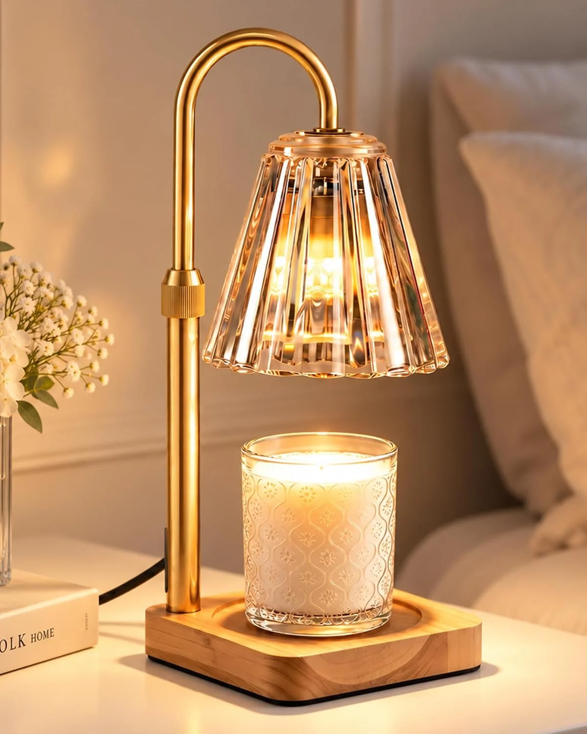 Gold-colored candle warmer lamp with a fluted glass shade positioned above a jar candle.