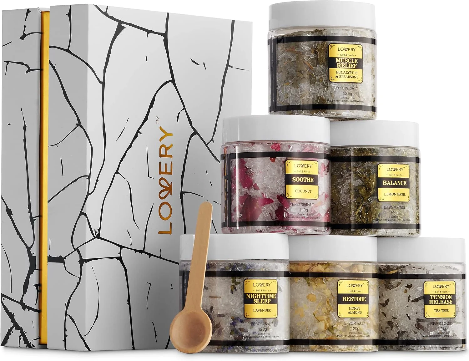 Six Lovery bath-salt jars with a wooden scoop beside a white and gold gift box.