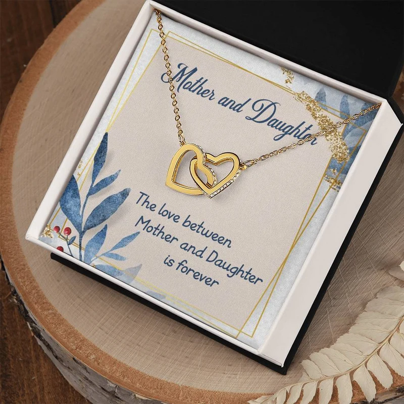Gold-colored interlocking-heart necklace displayed on a mother-and-daughter message card.